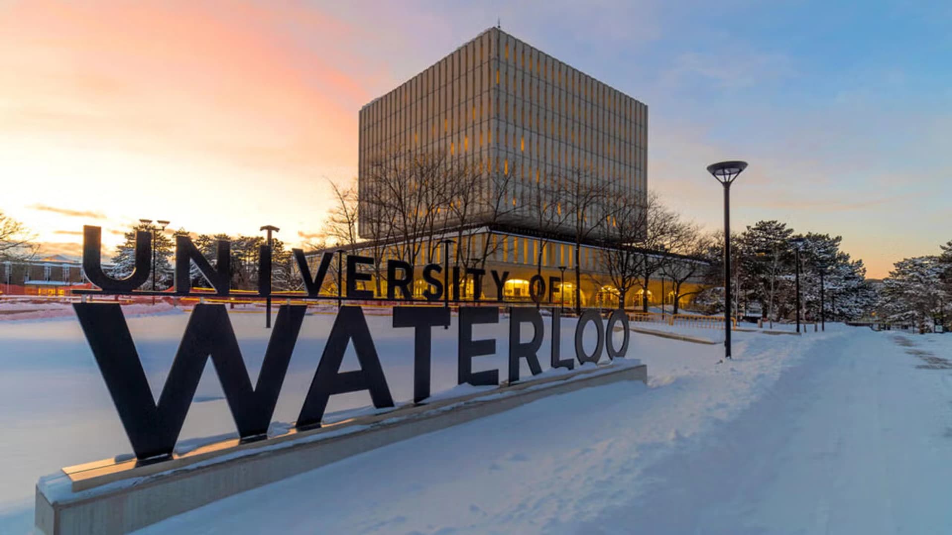 The University of Waterloo sign and Dana Porter Library at winter sunset
